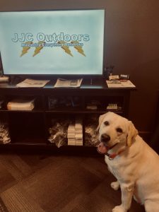 yellow lab in front of tv with jjc outdoors logo
